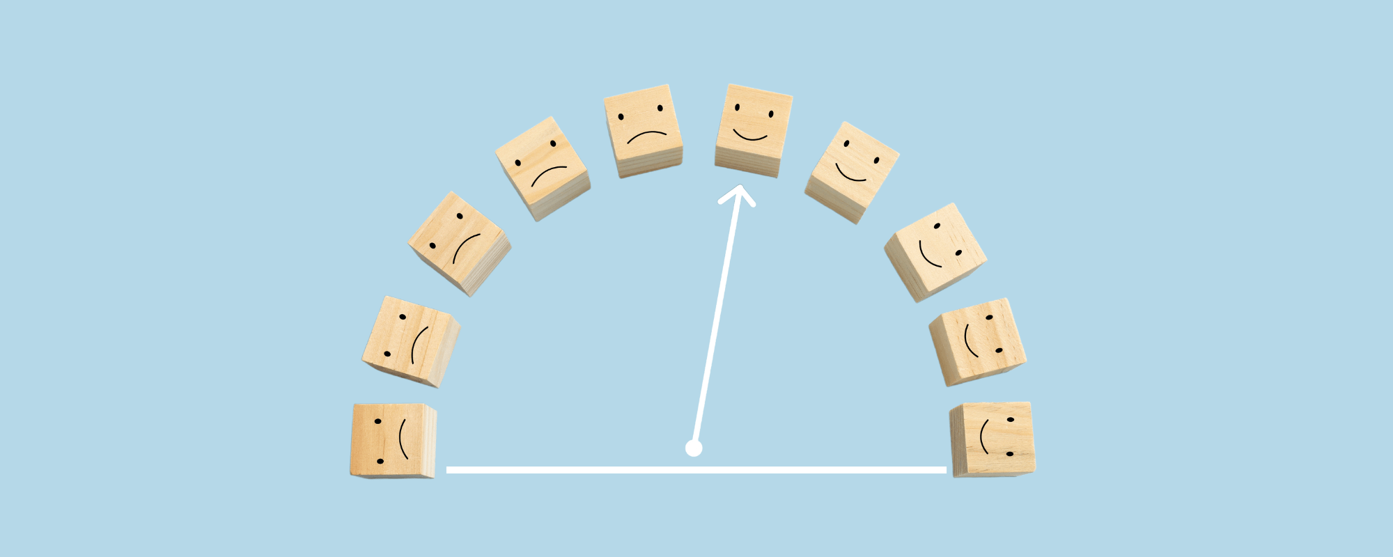 Vor einem mintblauen Hintergrund sind naturfarbene Würfel mit Strich-Punkt-Gesichtern zu einem Halbkreis angeordnet – wie ein Barometer. Eine weiße Tachonadel zeigt auf ein leicht lächelndes Gesicht. 