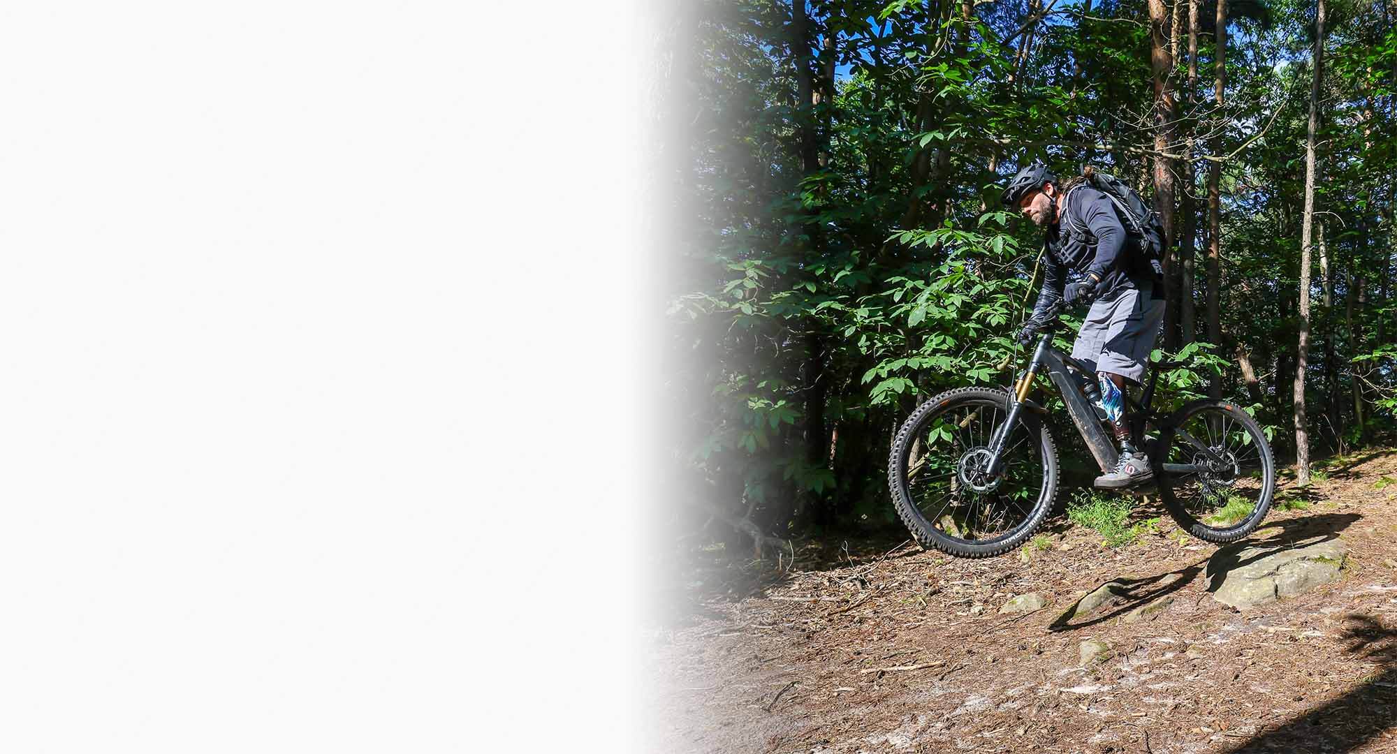 Alex Butz heizt auf einem Mountainbike durch den Wald.