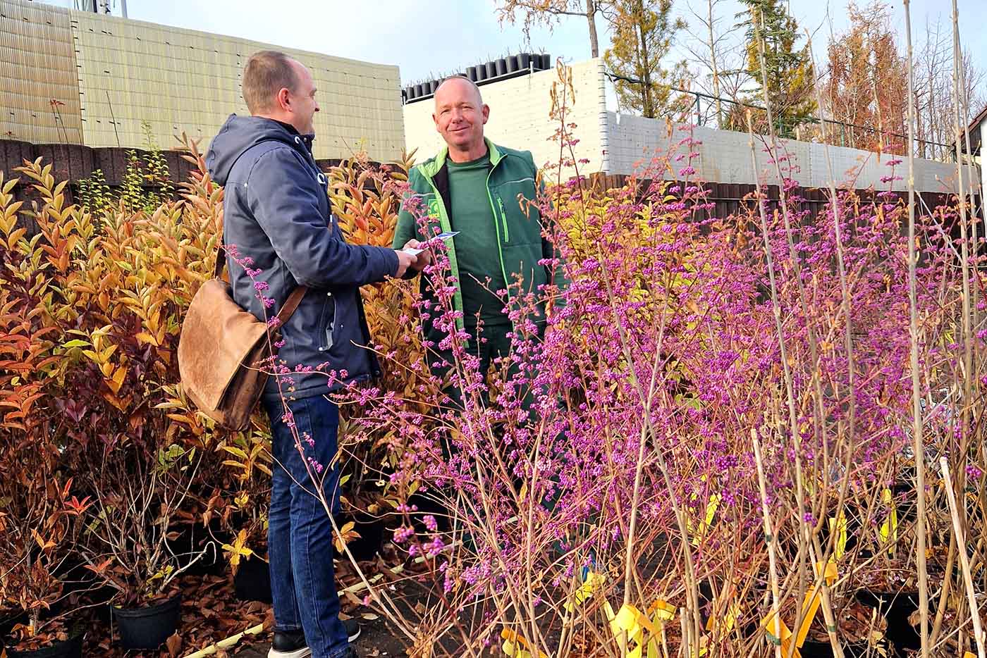 Johannes Kasper-Morelly und der Chef der Gärtnerei Nickel begrüßen sich im Blumenbeet. 